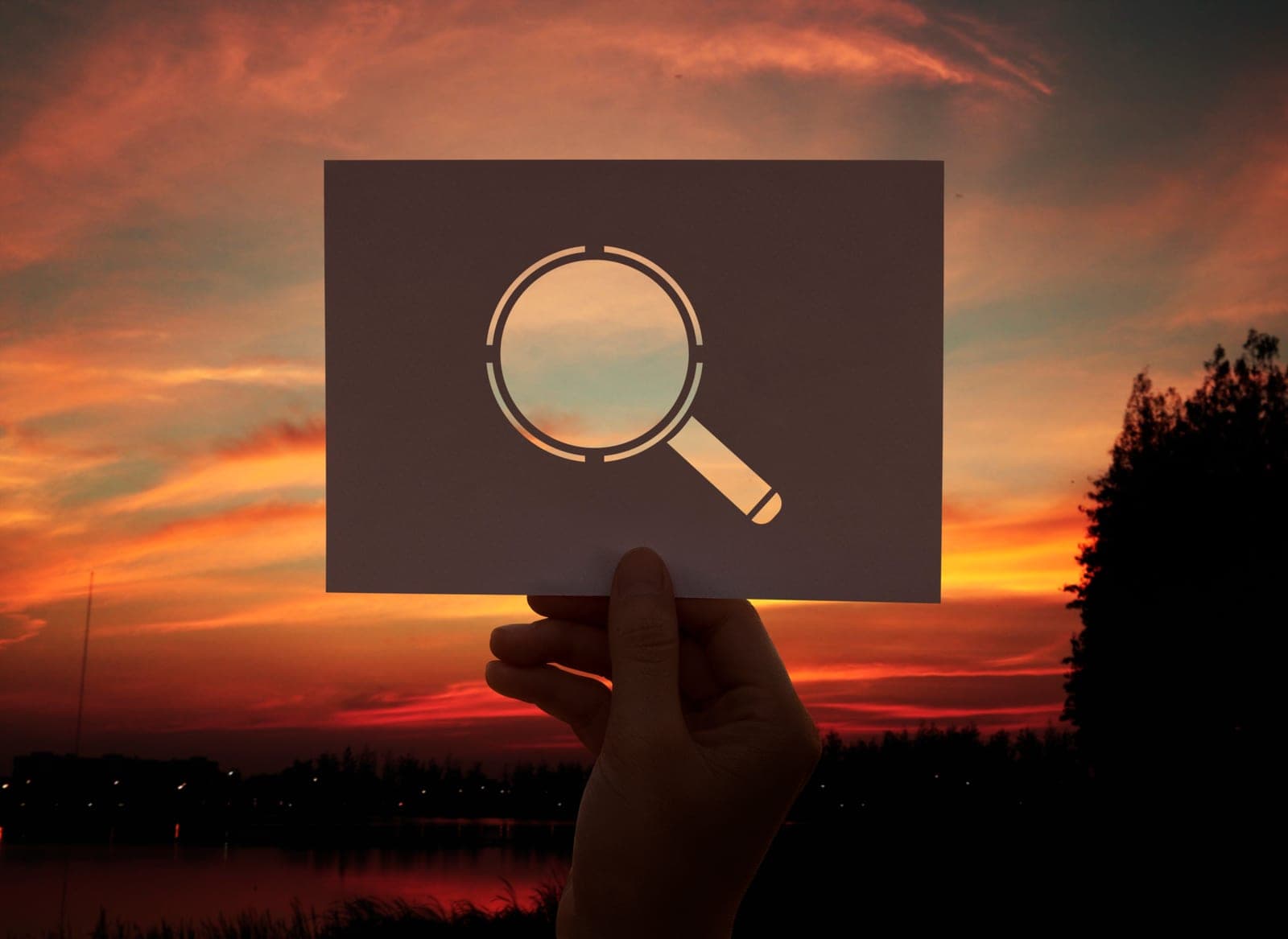 A magnifying glass over perforated paper, as an audit metaphor