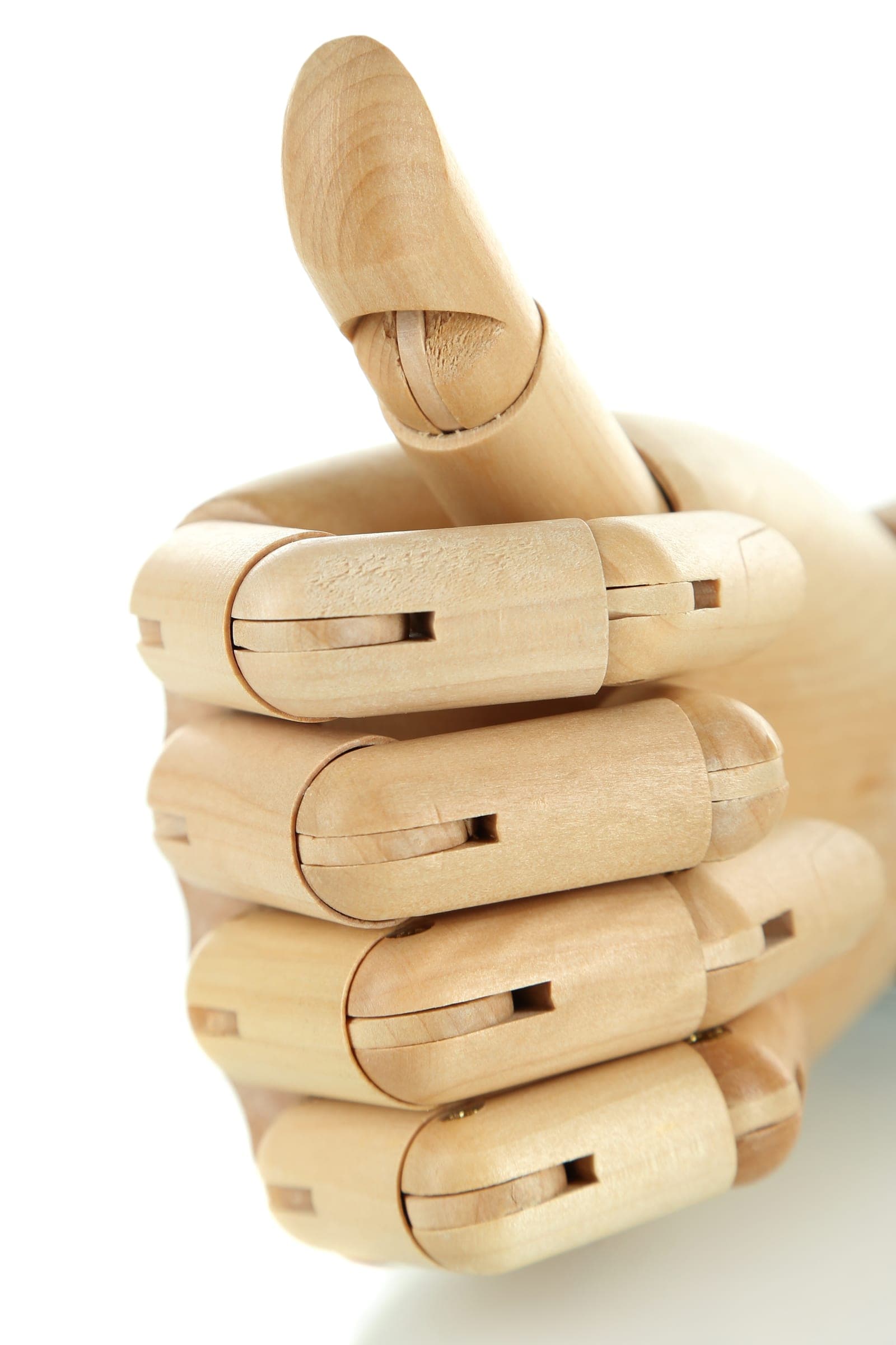 An articulated wooden hand on a white background